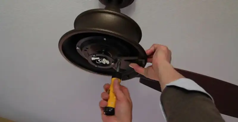 Electrician installing ceiling fan mounting bracket and fixture in Fresno, CA