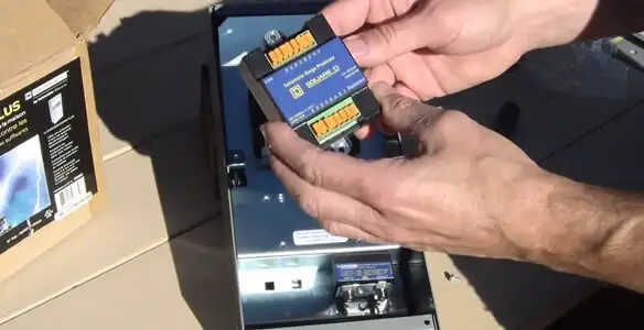 Electrician installing whole home surge protection unit inside main electrical panel in Fresno, CA