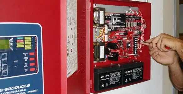 fire alarm installation service showing technician configuring fire alarm control panel in Fresno, CA