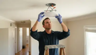 Electrician installs and wires a ceiling light fixture in a Fresno, CA home