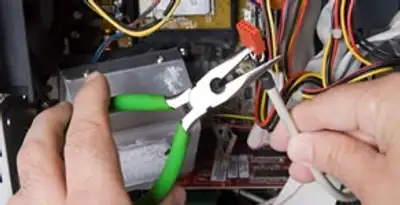 Licensed electrical contractor performing electrical repair with tools in Clovis, CA