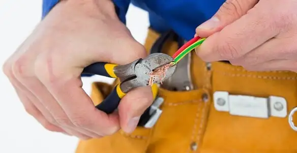 licensed electrician securing electrical wiring with professional tools during service work in Fresno, CA
