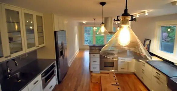 Residential electrician installing modern indoor light fixture in a home in Fresno, CA